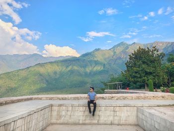 Man walking on mountain against sky