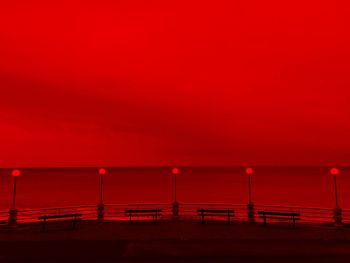 By the sea, evening light, red vision, horizon over the sea and street lamps 