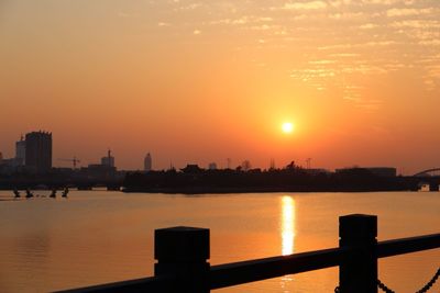 View of city at waterfront during sunset