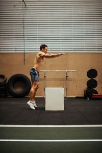 Shirtless man exercising in gym