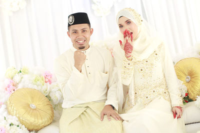 Portrait of wedding couple sitting on sofa