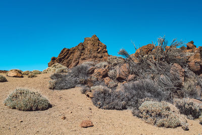 Panoramic shot of rocks on land against clear blue sky