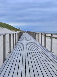 Surface level of pier over sea against sky