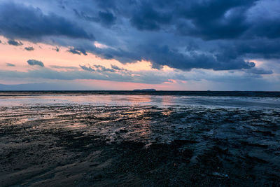 Scenic view of sea against dramatic sky during sunset