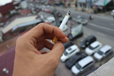 High angle view of person hand holding cigarette