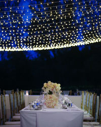 Lighting over empty dining table at dusk during wedding reception
