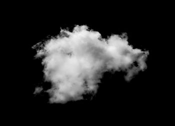 Low angle view of cloudy sky over black background