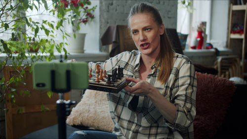 Teacher holding chessboard during online classes