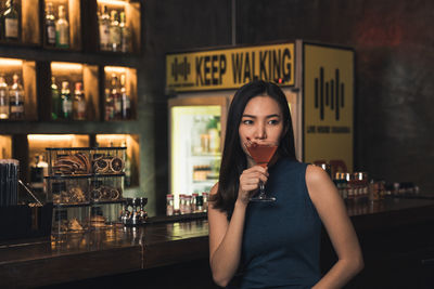 Portrait of young woman standing in restaurant