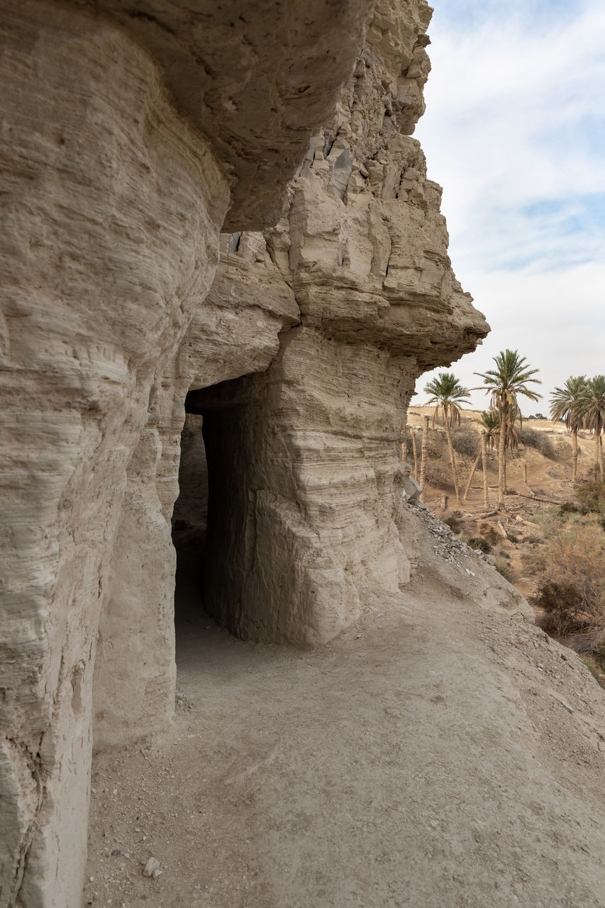 rock, nature, rock formation, architecture, sky, ancient history, arch, travel destinations, history, no people, travel, non-urban scene, cloud, geology, land, the past, ancient, scenics - nature, cave, physical geography, beauty in nature, landscape, desert, environment, ruins, day, old ruin, outdoors, plant, eroded, temple, built structure, extreme terrain, tourism, wadi, formation, tranquility, natural arch, climate, arid climate, tree, ancient civilization