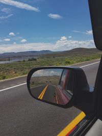 Empty road with reflection of mountain in background