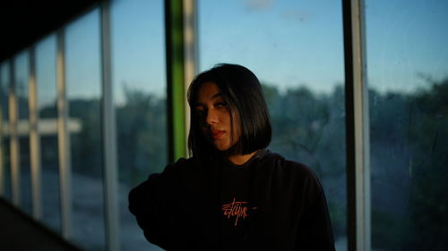 Young woman looking through window