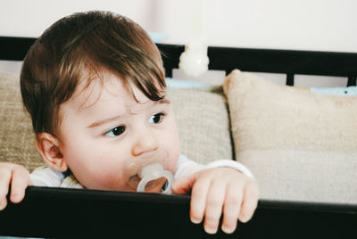 Close-up of cute baby boy sucking pacifier at home