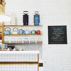 Utensils on shelf against wall with sign board