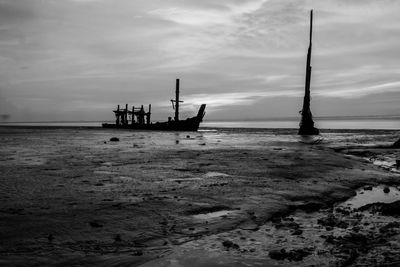 Silhouette boat in sea against sky