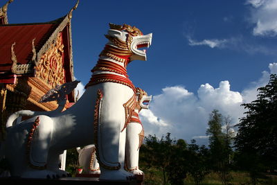 Low angle view of statue against temple against sky