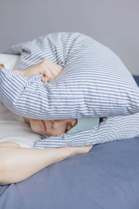 Low section of woman lying on bed at home