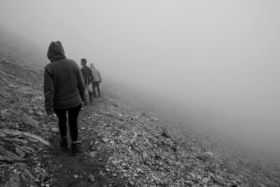 Rear view of men walking on landscape