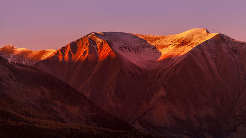 Scenic view of the sunset  over a mountain range against clear sky
