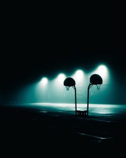 Illuminated street light on road at night