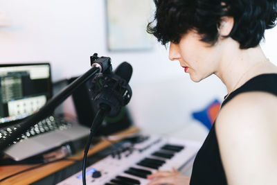 Side view of young woman using sound mixer