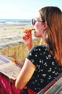 Young woman drinking coffee at beach