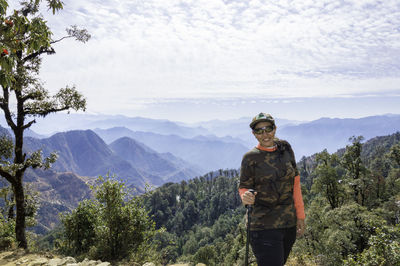 Beautiful woman standing on mountain against sky