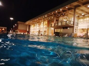 Swimming pool in illuminated building at night