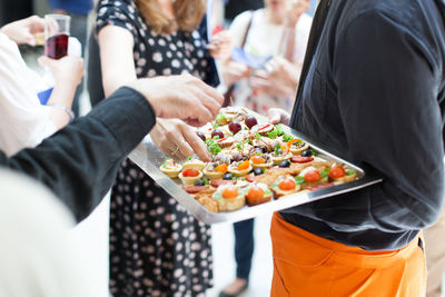 Midsection of man serving food in party