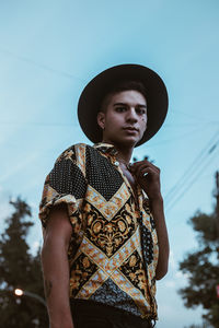 Portrait of young man standing against sky