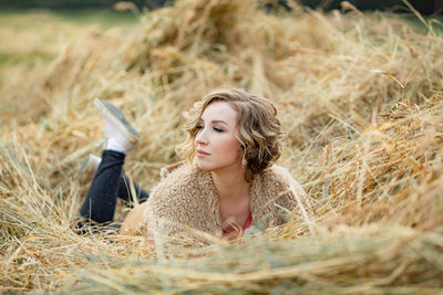 Portrait of a beautiful young woman lying on land