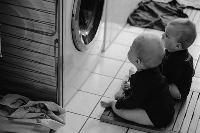 High angle view of cute kids sitting on floor at home