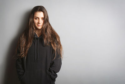 Portrait of smiling young woman against white background