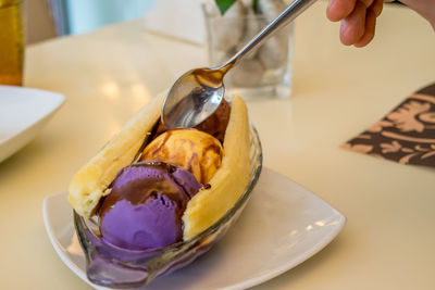 Close-up of hand holding ice cream in bowl