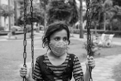 Portrait of woman holding swing in playground