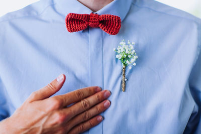 Midsection of man wearing flower on shirt