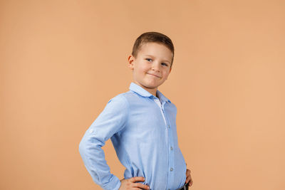 Portrait of young man standing against yellow background