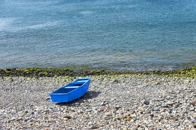 High angle view of blue on boat on pebbles at shore