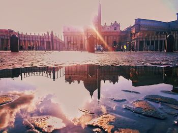 Reflection of buildings in lake during sunset