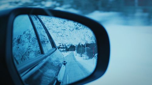 Reflection of sky on side-view mirror of car