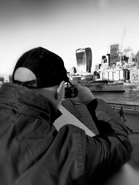 Man photographing with city in background