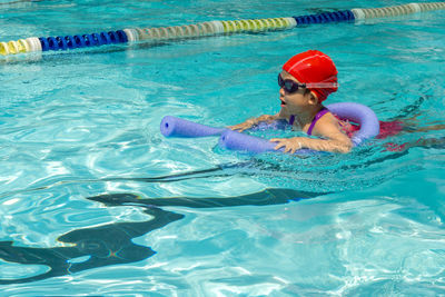 Girl with inflatable raft swimming in pool