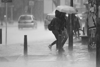 People walking on wet street during rainy season