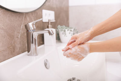 Cropped hands washing hand in sink
