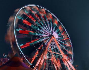 Low angle view of illuminated ferris wheel against sky at night