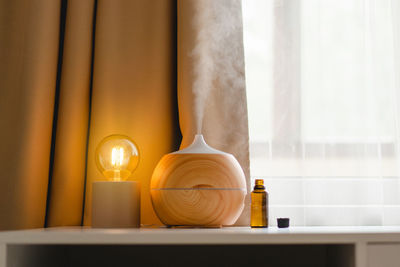 Aromatherapy concept. aroma oil diffuser on the table against the window.