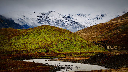 Scenic view of lake by mountains against sky