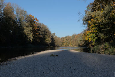 Road amidst trees against sky during autumn