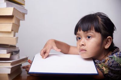 Portrait of girl with open book on table