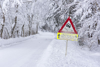 Road sign warns of ice and snow at winter